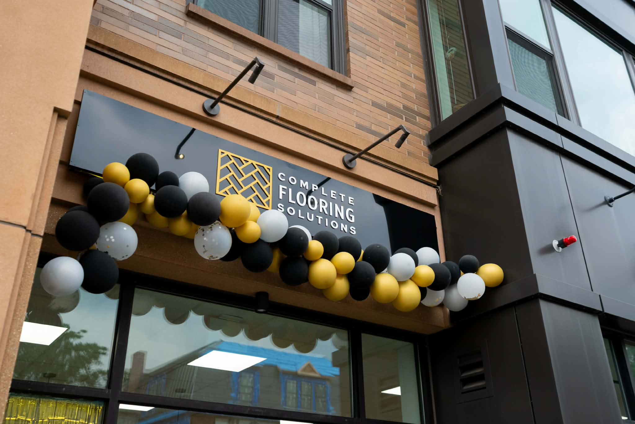 Complete Flooring Solutions storefront sign with black, white, and gold branding